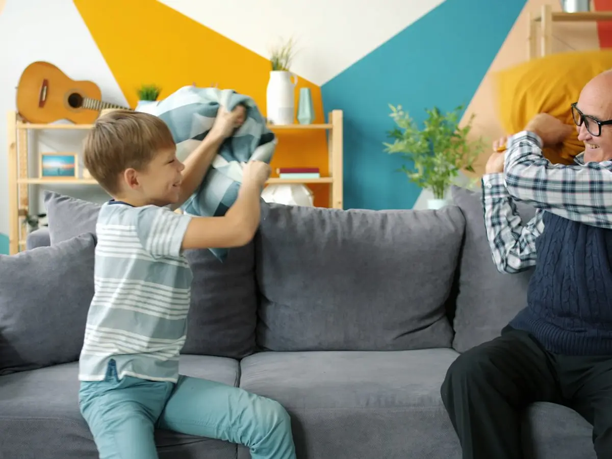 Un abuelo y su nieto se divierten juntos en el sillón